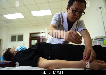 (190526) - Peking, 26. Mai 2019 (Xinhua) - ein Arzt mit Akupunktur Behandlung eines Patienten bei Cangzhou People's Hospital in Cangzhou, im Norden der chinesischen Provinz Hebei, 26. Mai 2019. Die traditionelle Medizin mit Ursprung aus der Traditionellen Chinesischen Medizin (TCM) wurde in der 11. Revision der Internationalen Klassifikation der Krankheiten (ICD) aufgenommen, markieren einen wichtigen Schritt zur Internationalisierung des TCM. Die Revision war am Samstag bei der 72. Weltgesundheitsversammlung in Genf, Schweiz, genehmigt, nach der China National Administration der Traditionellen Chinesischen Medizin. (Xinhua Stockfoto