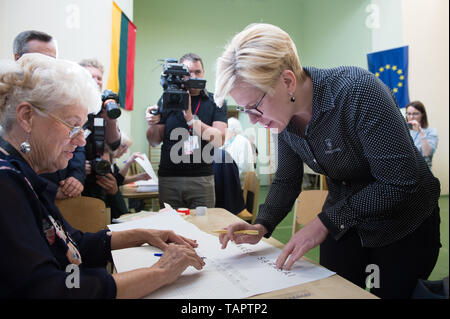 Vilnius, Litauen. 26 Mai, 2019. Ingrida Simonyte (vorne, R), der ehemalige Finanzminister und Präsidentschaftskandidat, Register zu einem Wahllokal in Wilna, Litauen, 26. Mai 2019. Die Presidential runoff trat weg in Litauen am Sonntag mit den ehemaligen Finanzminister Ingrida Simonyte und Ökonom Gitanas Nauseda Ringen für Top Job des Landes. Europäischen Parlament (EU) Wahlen in Litauen waren neben der Stichwahl statt. Credit: alfredas Pliadis/Xinhua/Alamy leben Nachrichten Stockfoto