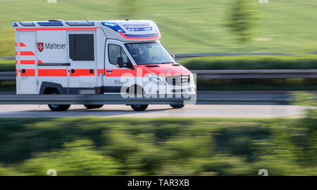 Leuna, Deutschland. 19 Mai, 2019. Ein Malteser Ambulanz Antriebe mit blauem Licht von der Unfallstelle mit einem Trainer. Mindestens eine Person getötet worden und zahlreiche Menschen ernst in den schweren Unfall auf der Autobahn 9 in der Nähe von Leipzig verletzt. Der Bus der Firma Flixbus der Fahrspur auf der A 9 in Richtung München links und umgeworfen. Mehr als 70 Passagiere an Bord waren zum Zeitpunkt des Unfalls. Die A9 wurde vollständig in beide Richtungen an der Unfallstelle geschlossen. Kredite: Jan Woitas/dpa-Zentralbild/dpa/Alamy leben Nachrichten Stockfoto