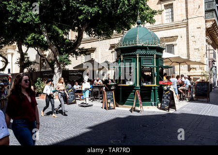 Street Café, das an einer belebten Straße Kreuzung in Valletta mit Touristen vorbei gehen. Stockfoto