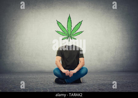 Surreale headless Kerl, unsichtbare Fläche am Boden sitzend mit Marihuana Blatt Symbol anstelle von Kopf, als Gehirn heilen. Legalisierung von Cannabis als Medizin d Stockfoto