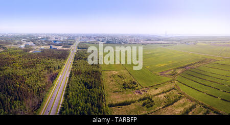 Den langen, geraden Autobahn vom Land in die große Stadt eingetragen. Panoramablick auf das Luftbild. St. Petersburg, Russland Stockfoto
