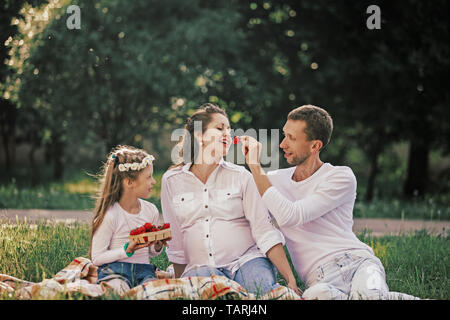 Happy Family Erdbeeren genießen beim Picknick. gute Zeit Stockfoto