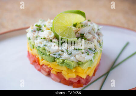Ein hausgemachtes Seespinne Fleisch in einem Herzen stack-förmigen Werkzeug bestehend aus einem Sockel von gehackten Tomaten, Mango, Avocado und gekocht, gekühlt sp Stockfoto
