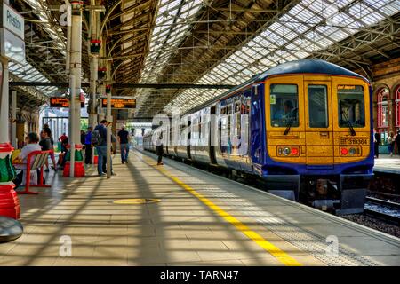 Preston, Großbritannien - 14 Mai 2019: Preston Bahnhof in North West England mit dem Zug am Gleis und Passagiere einige Bewegung verschwommen auf adj Stockfoto