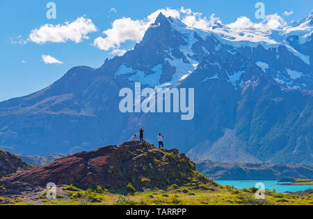 Drei Touristen nach See Pehoe und die Anden Gipfel der Torres Cuernos Del Paine Torres del Paine Nationalpark, Patagonien, Chile. Stockfoto