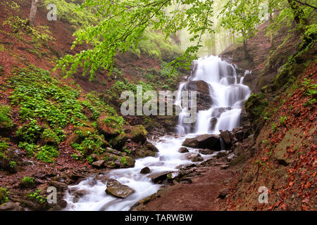 Der schnelle Informationsfluss in das klare Wasser des Shypit Wasserfall macht seinen Weg unter einer Kaskade von Stein Felsbrocken in die Karpaten Wald in den frühen Morgen Stockfoto