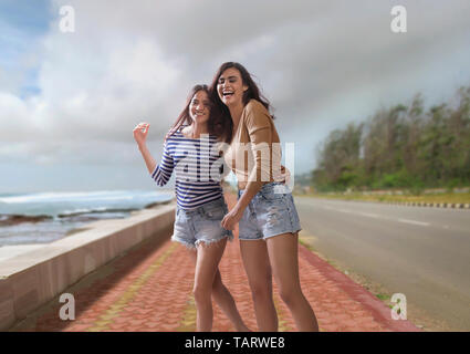 Zwei Frauen zusammen zu Fuß auf der Straße neben dem Meer Stockfoto