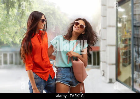 Zwei Frauen in der Sonnenbrille zu Fuß auf der Straße fröhlich Stockfoto