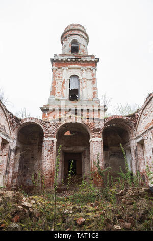 Ruinen Glockenturm der verlassenen Kirche. Gebäude mit eingestürzten Gewölbe ist zerbrochen Ziegel und bewachsene Gras und Büschen bedeckt. Kirche der Geburt der Stockfoto