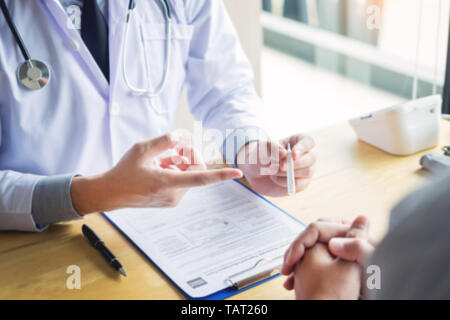 Hand eines Arztes mit Stethoskop. Temperatur, Fieber, Grippe oder Diagnose- und kranke Patienten, die im Krankenhaus Stockfoto