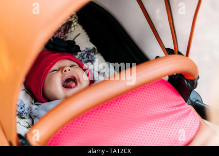 Kleines Mädchen in einem Kinderwagen weinend Stockfoto
