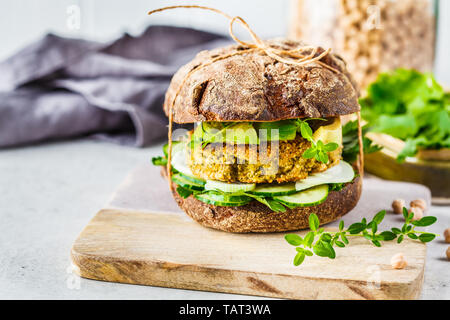 Vegan Sandwich mit Kichererbsen Schnitzel, Avocado, Gurke und Grüns in Roggenbrot. Stockfoto