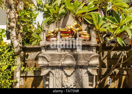 Triple stone Altar zu Trimurti - Brahma, Shiva und Vishnu mit traditionellen hinduistischen Balinesen Angebote canang Sari. Bali, Indonesien. Stockfoto