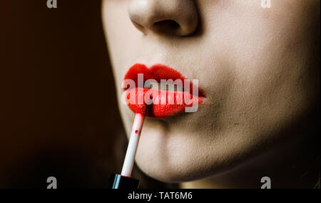 Junge Frau mit glatter Haut Anwendung roten Lippenstift Stockfoto
