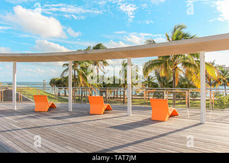 3 Orange Lounge Sessel mit Blick auf South Pointe Park in Miami Beach, Florida, USA. Stockfoto