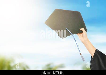 Hand, die Graduierung hut mit blauer Himmel. Staffelung Konzept Stockfoto