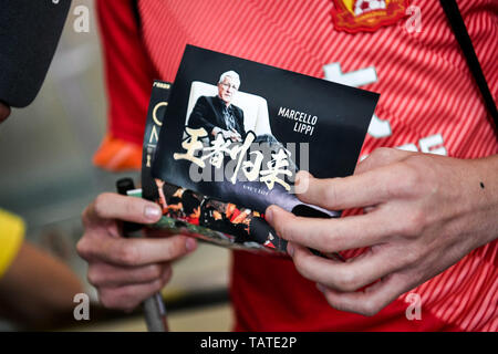 Chinesische Fans halten Banner Unterstützung von Marcello Lippi Zurück zur zweiten Stint als Cheftrainer der chinesischen Nationalmannschaft an der Guangzhou Baiyun International Airport in der Stadt Guangzhou, Provinz Guangdong im Süden Chinas, 28. Mai 2019 zu zeigen. Stockfoto