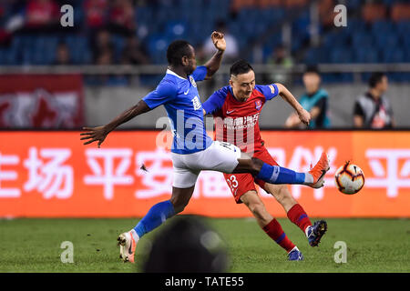 Kamerunischer Fußballspieler Christian Bassogog, Links, Henan Jianye passt den Ball gegen einen Spieler von Chongqing SWM in ihren 11. Runde während der 2019 chinesischen Fußballverband Super League (CSL) in Chongqing, China, 24. Mai 2019. Chongqing SWM gespielt zu Henan Jianye 0:0-Unentschieden. Stockfoto