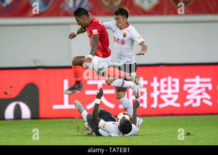 Brasilianische Fußballspieler Paulinho, oben, von Guangzhou Evergrande Taobao passt den Ball gegen Spieler von Shenzhen F.C. in der 11. Runde während der 2019 chinesischen Fußballverband Super League (CSL) in der Stadt Guangzhou, Provinz Guangdong im Süden Chinas, 26. Mai 2019. Guangzhou Evergrande Taobao besiegt Shenzhen F.C. 1-0. Stockfoto