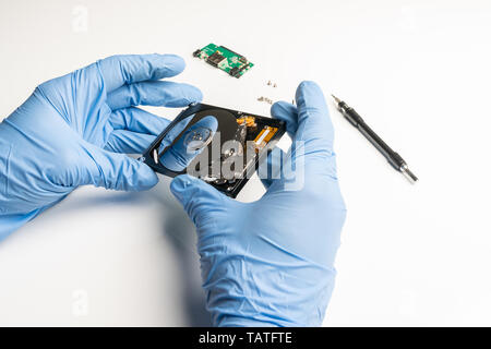 Steuerung einer Festplatte unter Laborbedingungen mit Handschuhen Stockfoto