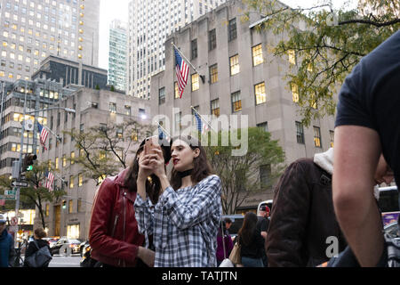 Zwei schöne Mädchen sind die Aufnahme von Fotos und selfies vor dem Rockefeller Plaza. Stockfoto