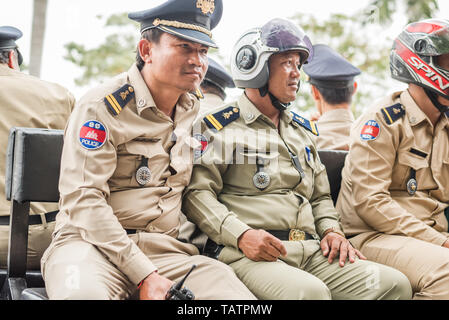 Phnom Penh, Kambodscha - Januar 17, 2019: Eine Gruppe von kambodschanischen Polizisten sitzt auf der Bank in der den Körper des Pickup. Stockfoto