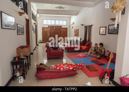 Phnom Penh, Kambodscha - Februar 8, 2019: Mehrere couchsurfers Chill Out auf Sofas und Matten in der Wohnung. Stockfoto