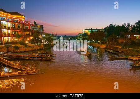 Die Dämmerung über den Kanal mit Kanu Boote in der Mitte des Naungshwe Resort - ein Punkt der Inle See Feuchtgebiet Heiligtum, Shan Staat, Myanmar. Stockfoto