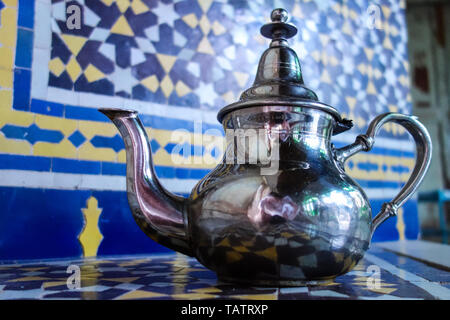 Silber metall Tee Wasserkocher mit Mosaiken Hintergrund stehen in einem Palast in Fez, Marokko Stockfoto