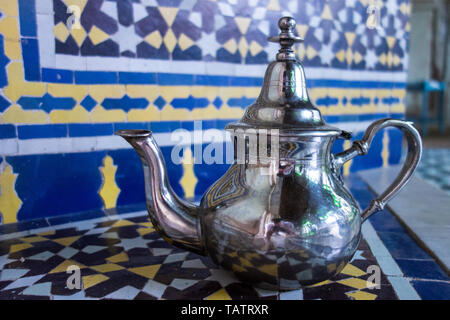 Silber metall Tee Wasserkocher mit Mosaiken Hintergrund stehen in einem Palast in Fez, Marokko Stockfoto