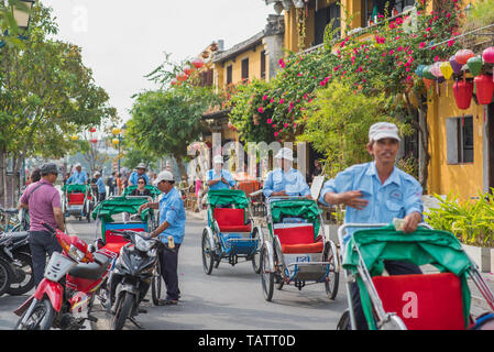 Hoi An, Vietnam - Oktober 28, 2018: die Altstadt mit ihren Rikschas, gelbe Häuser, Laternen, üppige Vegetation und Blumen. Stockfoto