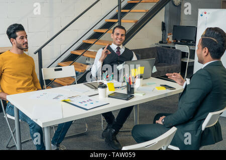Business Meeting der jungen Unternehmer, die sich an einem Tisch im Büro sind. Stockfoto