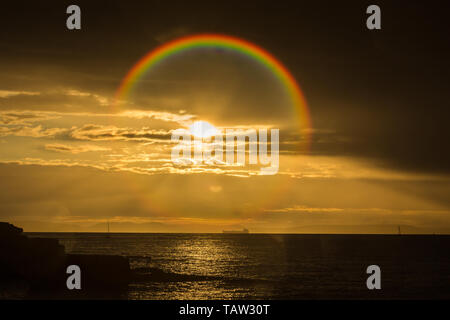 Portland, Dorset, Großbritannien. 28 Mai, 2019. Direkte Sonneneinstrahlung in die Linse der Kamera, wodurch ein Regenbogen Effekt wie ein Segelboot und Tanker am Horizont als Morgendämmerung bricht über die Küste von Dorset. Wolke und Sonne bringen wechselhafter Witterung für heute. Peter Lopeman/Alamy leben Nachrichten Stockfoto