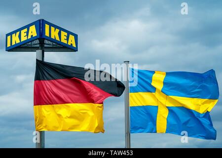 Berlin, Deutschland. 25 Mai, 2019. 25.05.2019, die Deutsche und die Schwedische Nationale Fahnen wehen im Wind vor dem Typenschild eines IKEA-Filiale in Berlin mit einem bewölkten Himmel im Hintergrund. | Verwendung der weltweiten Kredit: dpa/Alamy leben Nachrichten Stockfoto