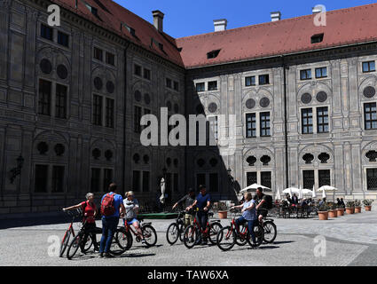 München, Deutschland. 24. Mai, 2019. Die Menschen fahren Fahrräder auf einem Platz ausserhalb der Residenz München in München, Deutschland, 24. Mai 2019. In den nördlichen Ausläufern der Alpen im Süden Deutschlands, München ist die Hauptstadt des Freistaates Bayern. Es zählt in Deutschland zu den großen wirtschaftlichen, kulturellen, wissenschaftlichen, technologischen und Zentren und einer der wohlhabendsten Städte Europas. Credit: Lu Yang/Xinhua/Alamy leben Nachrichten Stockfoto