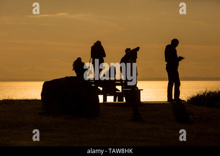 Portland, Dorset, Großbritannien. 28 Mai, 2019. Eine Gruppe von Menschen sind gegen die tiefstehende Sonne auf dem Meer ab, als sie den warmen am späten Nachmittag auf der Isle of Portland, Dorset genießen. Peter Lopeman/Alamy leben Nachrichten Stockfoto