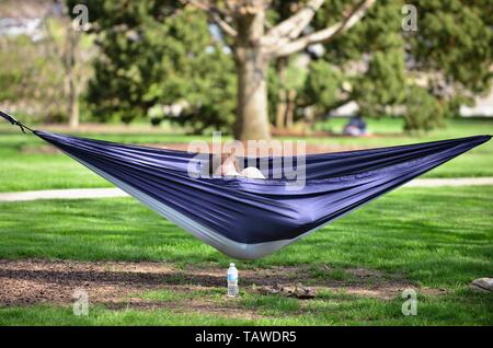 Wheaton, Illinois, USA. Eine Studentin entspannt in der Hängematte auf dem Campus der Wheaton College. Stockfoto