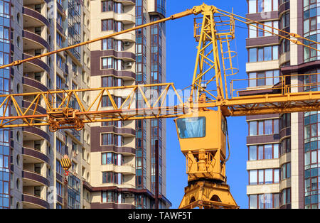 Ein Fragment der Fassade der Häuser im Bau, ein modernes Gebäude gebaut, der Turm Kran des Gebäudes steht zwischen den Häusern Aga Stockfoto