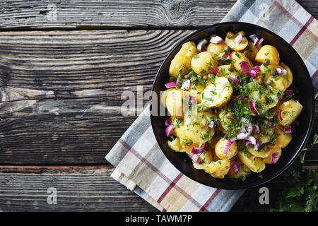 Köstliche neue Kartoffel Salat mit roten Zwiebeln, Kapern, Grüns in einem schwarzen Schüssel, horizontale Ansicht von oben, Kopie Raum Stockfoto