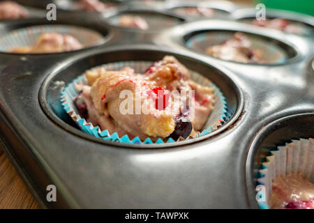Rohen Teig mit Früchten für köstliche Muffins in der Dose Stockfoto