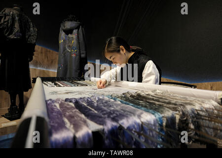 Junge Frau nähen traditionelle Seidenstickerei in einer Lagerhalle des ehemaligen Weingut wurde umgewandelt in eine multifunktionale Kultur Komplex namens Huashan 1914 Creative Park in Zhongzheng District, Taipei, Taiwan Stockfoto