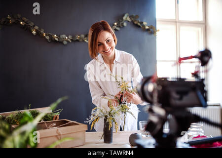 Junge kreative Frau vlogger in einem Blumenladen. Ein Anlauf von Blumengeschäft Geschäft. Stockfoto