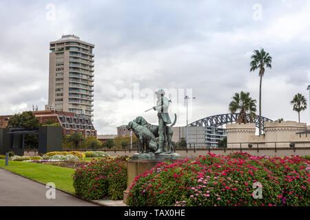 Blick auf die Stadt von den Royal Botanic Gardens in Sydney mit Statue von Jäger und Hunde im Vordergrund. Stockfoto