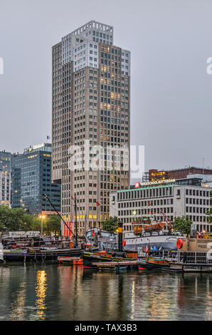 Rotterdam, Niederlande, 20. Mai 2019: De Coopvaert Wohnturm und angrenzenden Gebäuden in den Leuvehaven museum Hafen bei Dämmerung spiegeln Stockfoto