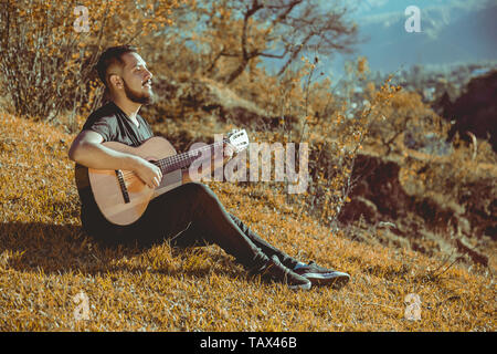 Mann spielt Gitarre auf Berge Stockfoto