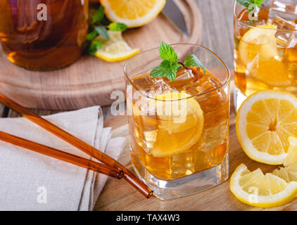 Nahaufnahme von einem Glas erfrischender Eistee mit Zitronenscheiben und Eiswürfel Stockfoto