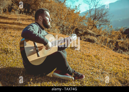 Mann spielt Gitarre auf Berge Stockfoto