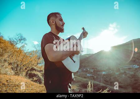 Mann spielt Gitarre auf Berge Stockfoto