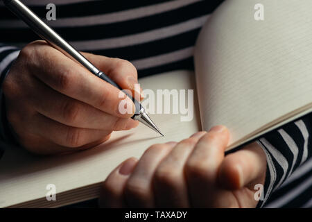 Schwangere Frau eine Schwangerschaft Tagebuch, in der Nähe der Hände schreiben im Notebook Stockfoto